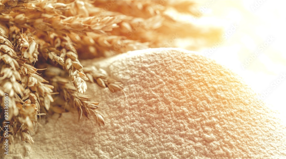 Wheat ears and flour on  background