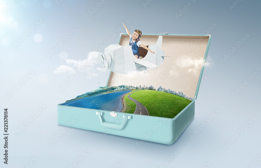 Little asian girl enjoy with fantasy cardboard plane fly and floating in an open retro vintage suitc