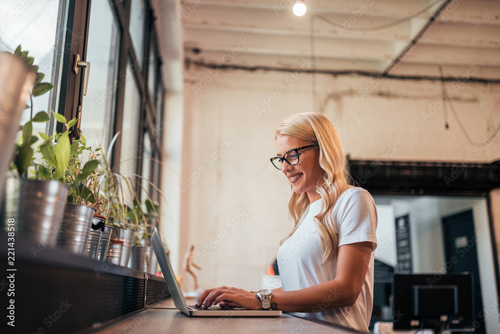 Side view of beautiful woman working on laptop.