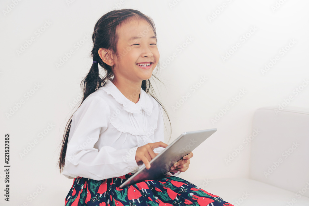 Little kid on white background with tablet.