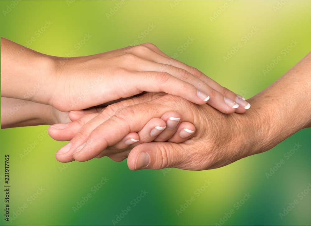 Hands of the old man on green background