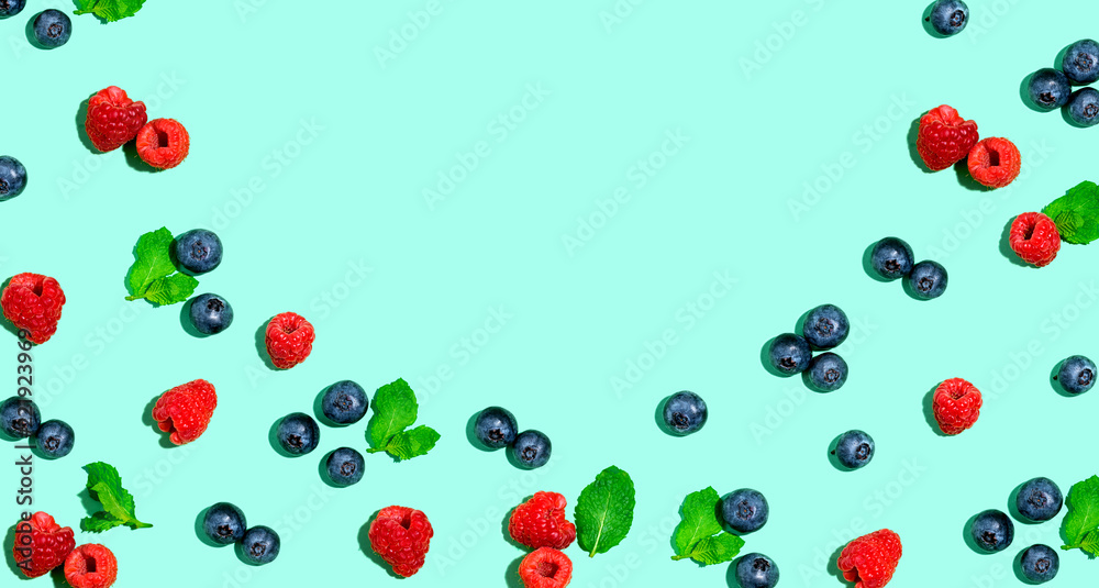 Blueberries and raspberries on a solid color background