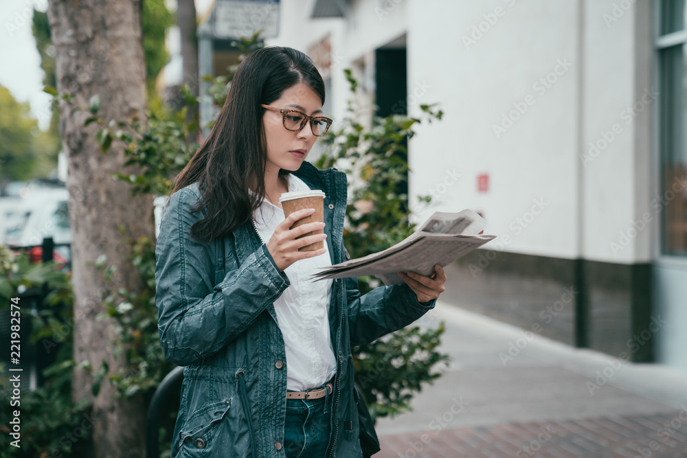 女人边喝咖啡边看报纸