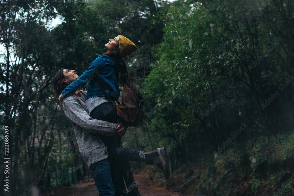 Yung couple enjoying in rain at forest