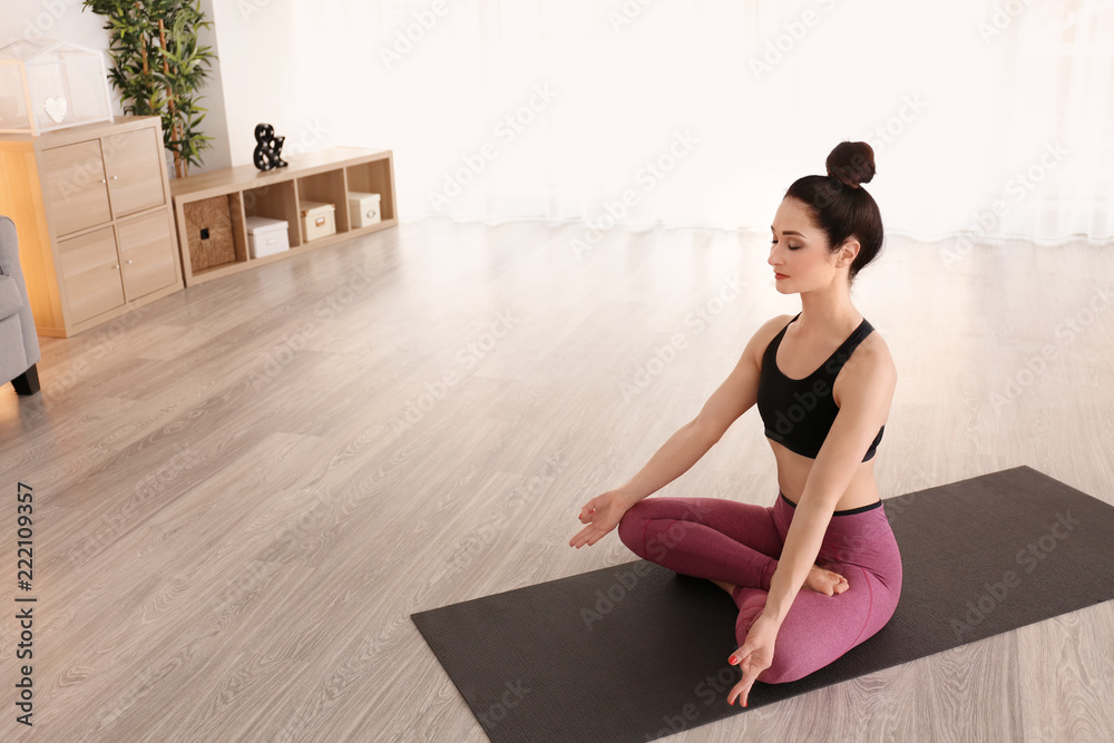 Beautiful woman practicing yoga indoors