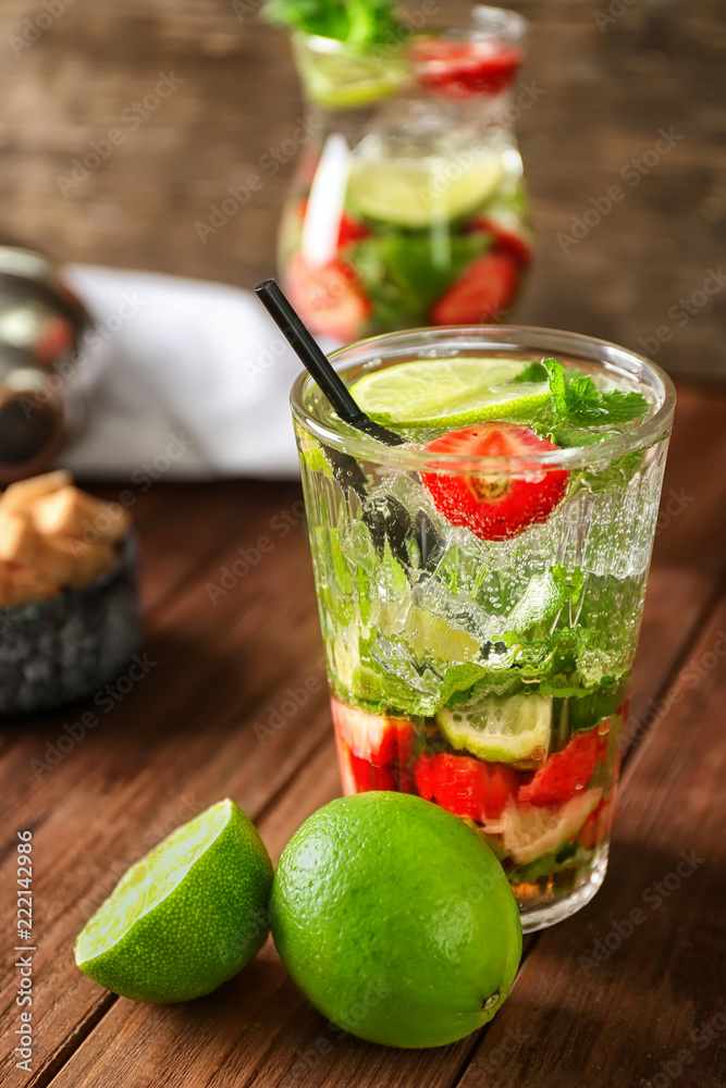 Glass of fresh strawberry mojito on wooden table