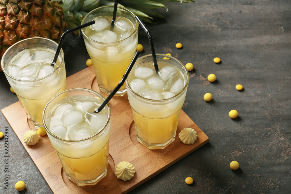 Glasses with fresh tasty pineapple cocktail on dark background