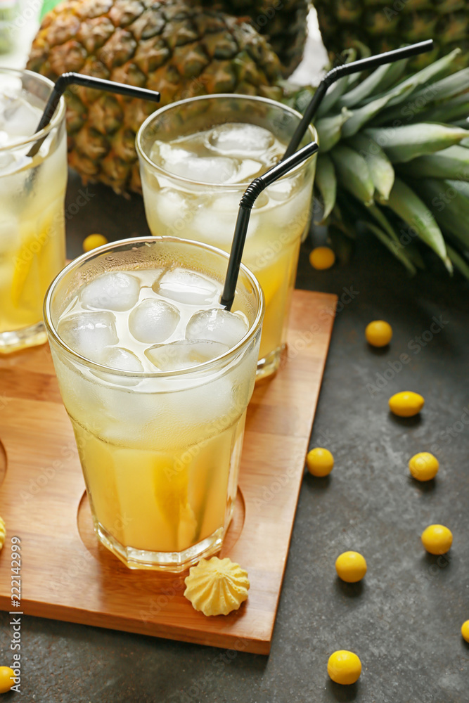 Glasses with fresh tasty pineapple cocktail on dark background