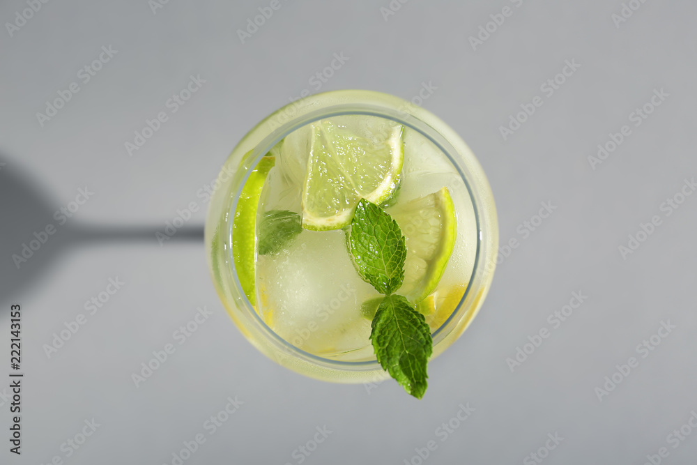 Glass of fresh cocktail on grey background