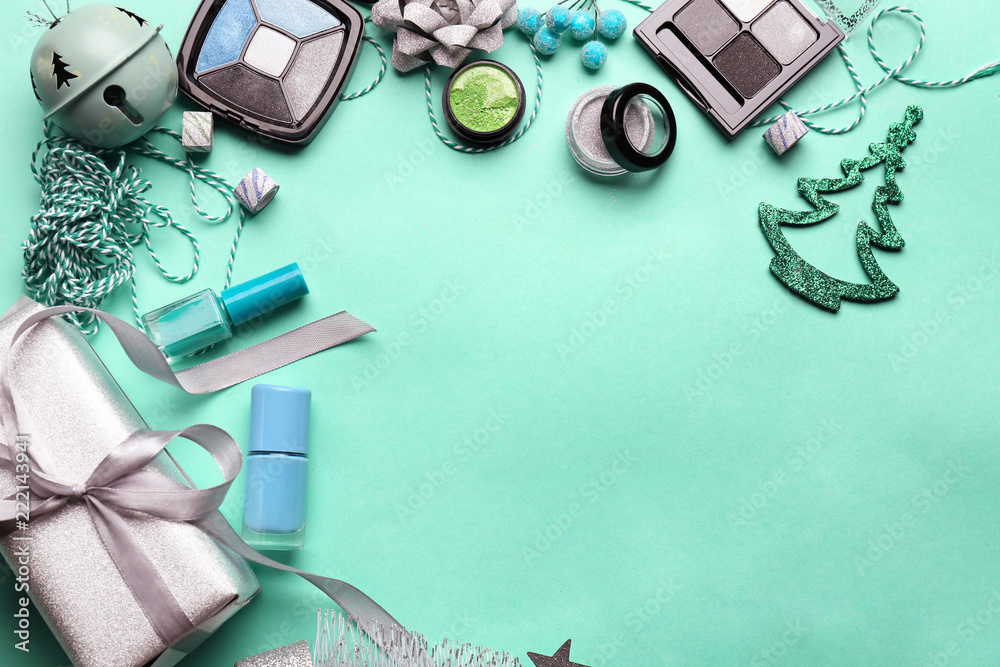 Set of cosmetics with Christmas present and decorations on color background