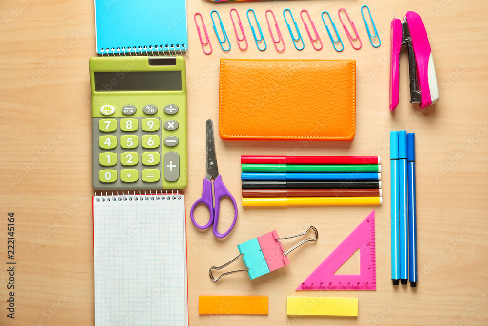 Composition with different school stationery and calculator on wooden background