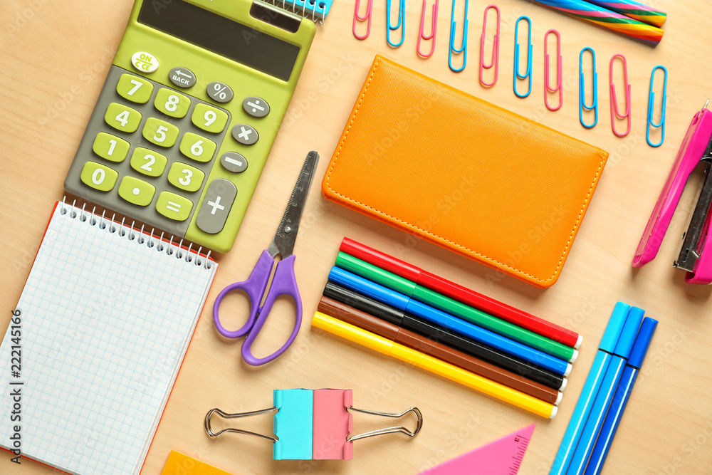 Composition with different school stationery and calculator on wooden background