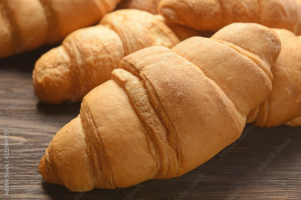 Tasty croissants on wooden table