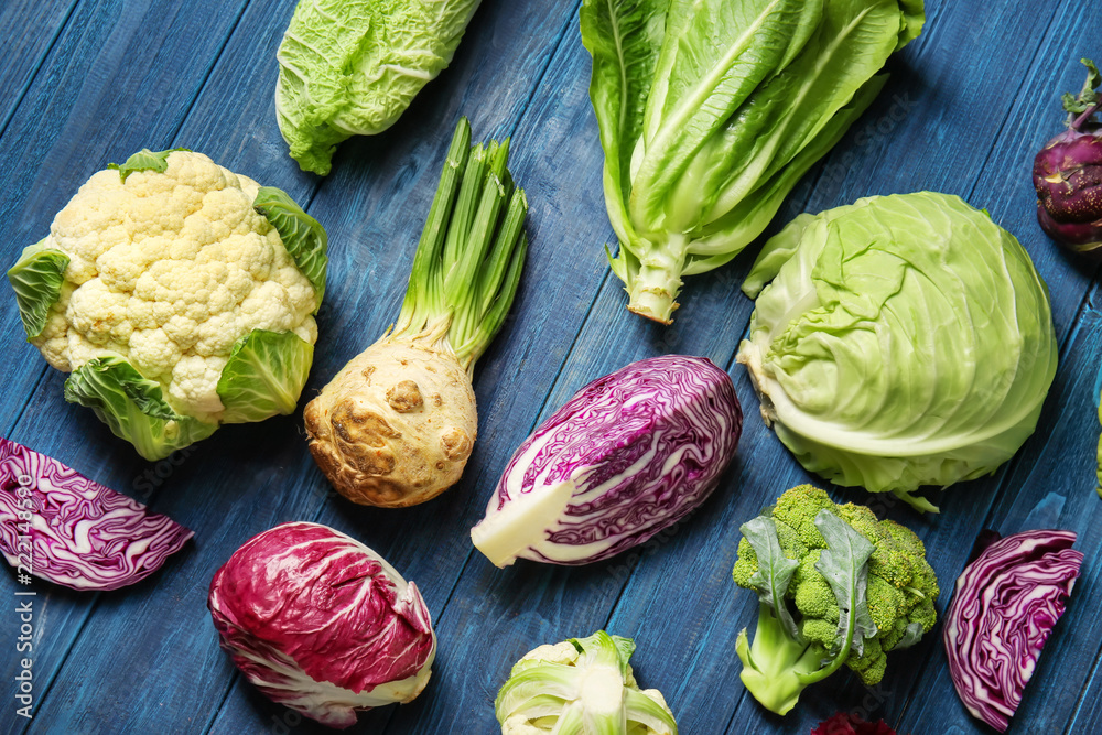 Different types of cabbage on color wooden background