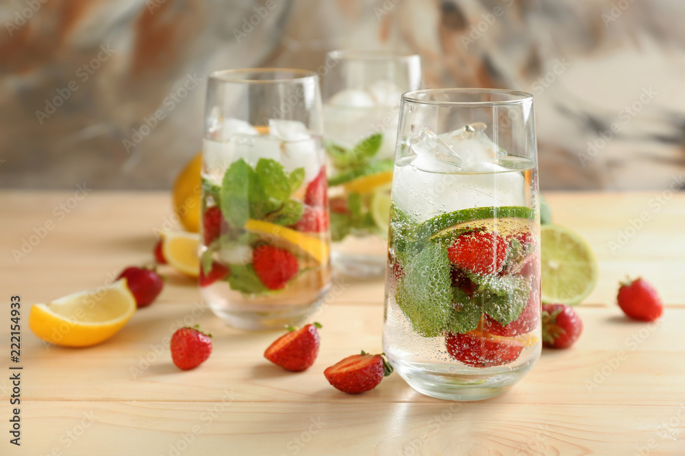 Glasses of fresh strawberry lemonade on wooden table