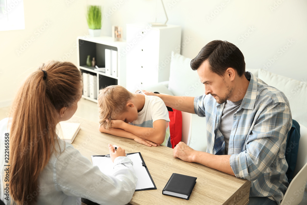 Young man and his son meeting with headmistress at school