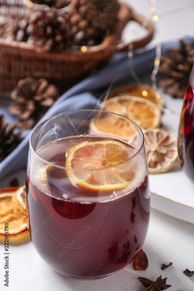 Glass of delicious hot mulled wine on light table