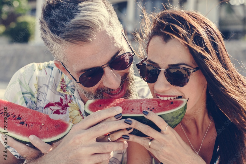 Couple eating watermelon at the beach