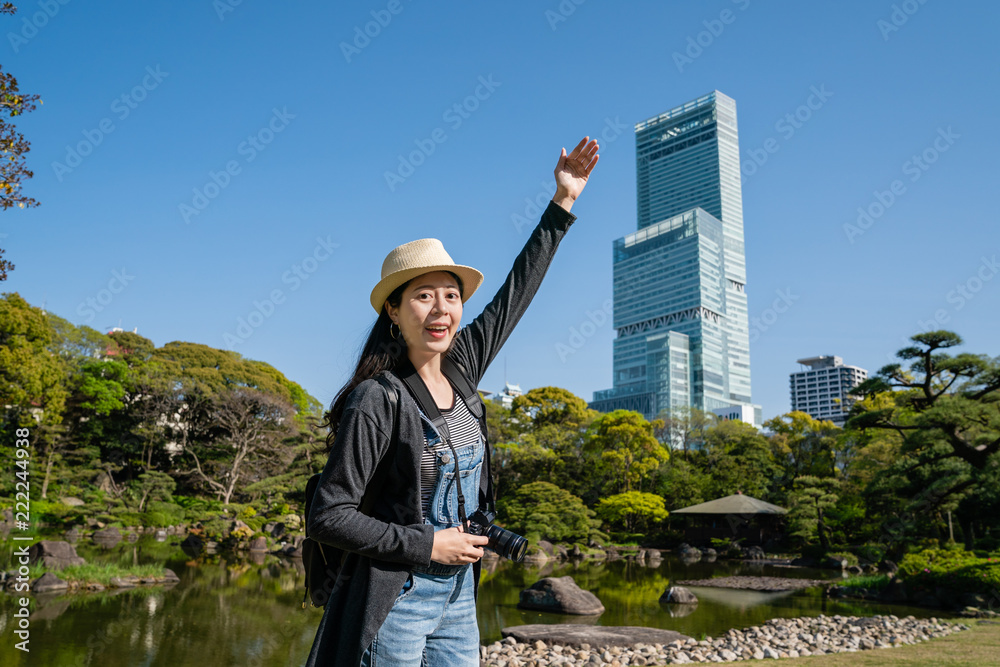 女子举起手臂介绍高楼