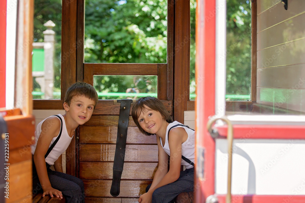 Beautiful children, dressed in vintage clothes, enjoying old steam train on a hot summer day