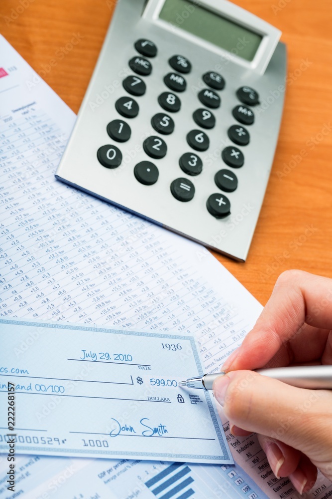 Close-up of a Businesswoman Signing a Check on Desk