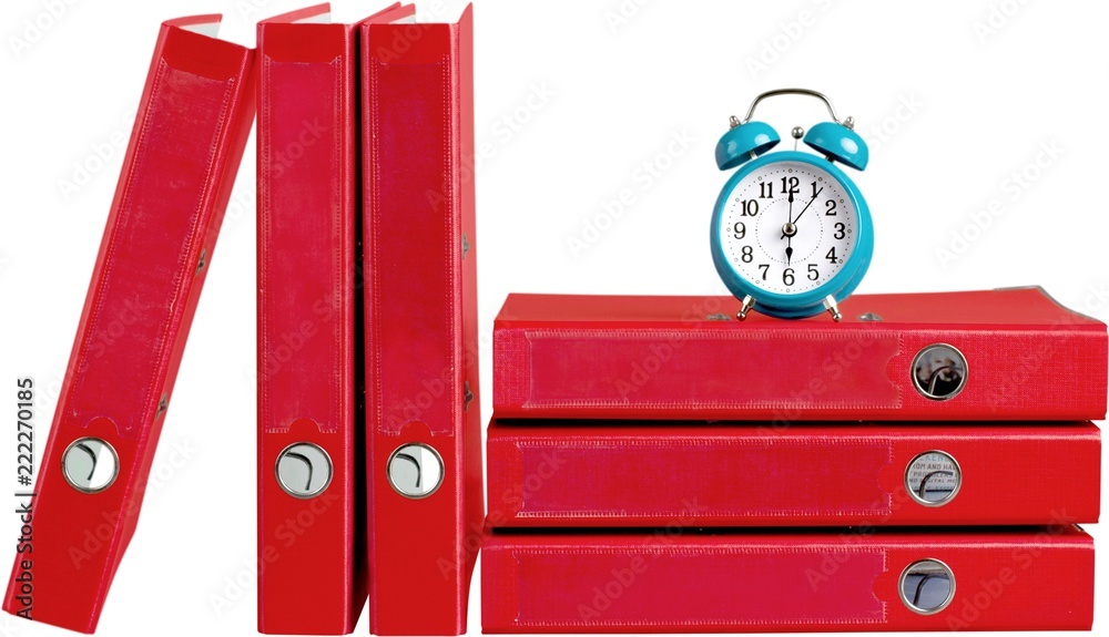 File organizers/binders with an alarm clock on top of them