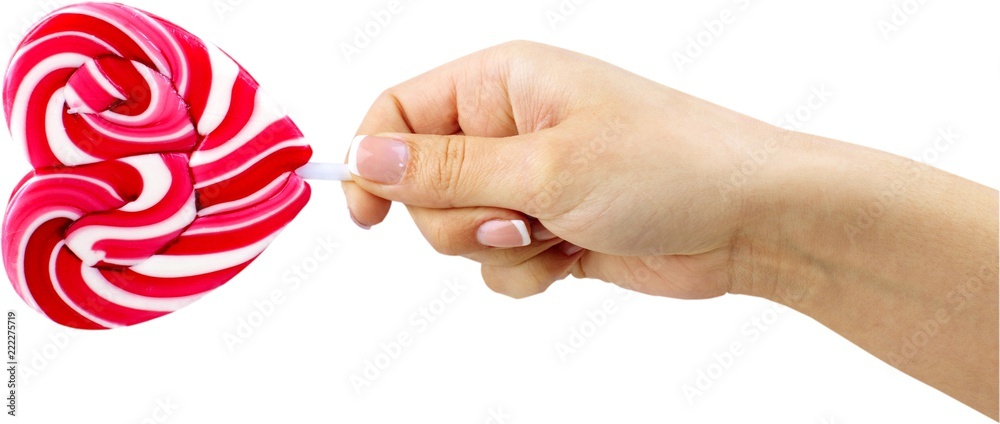 A Hand Holding A Heart Shaped Lollipop - Isolated