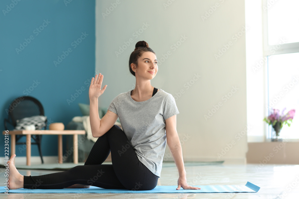 Young woman practicing yoga at home