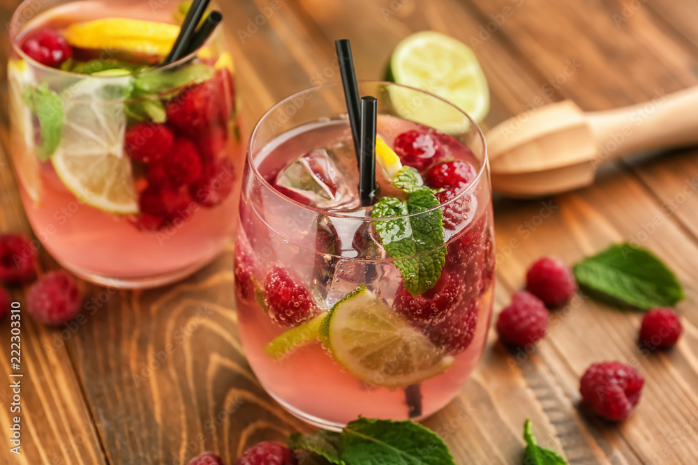 Glasses of fresh raspberry mojito on wooden table