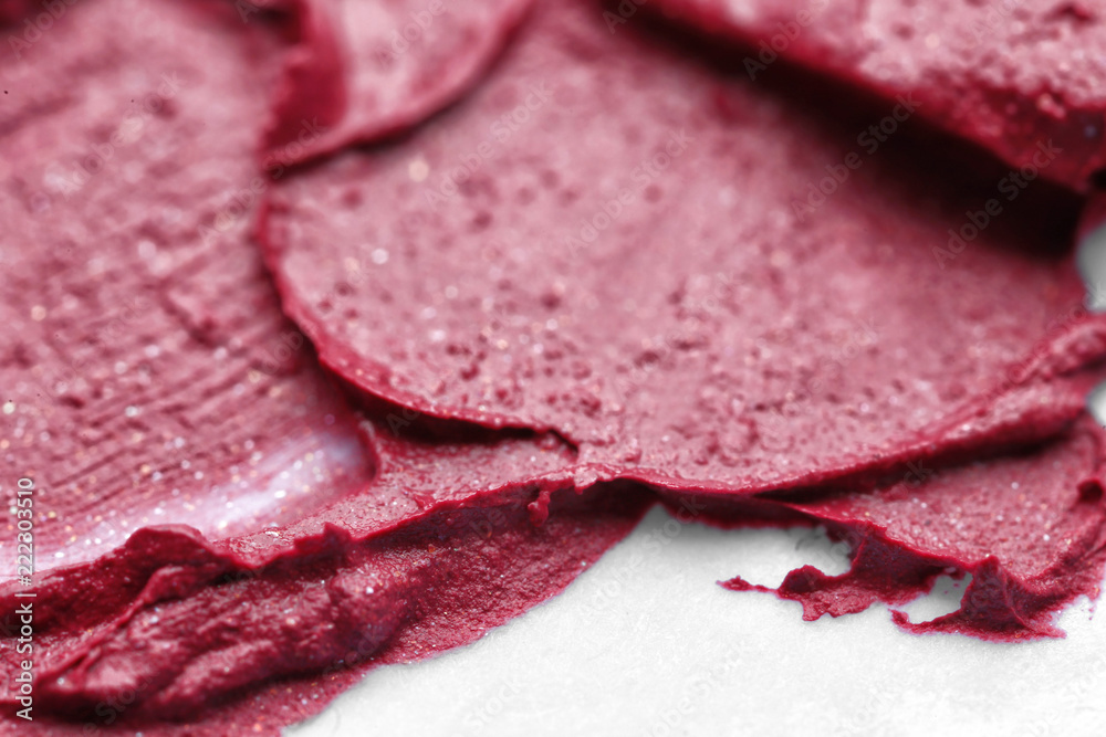 Sample of color lipstick on white background, closeup