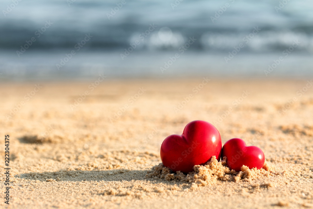 Small red hearts on beach sand