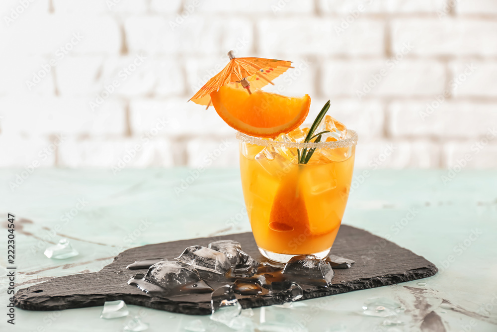 Glass of tasty cold cocktail on slate plate