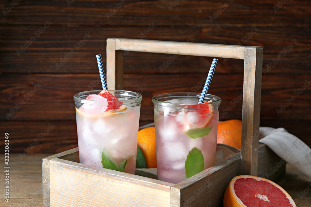 Glasses of refreshing grapefruit lemonade in wooden basket