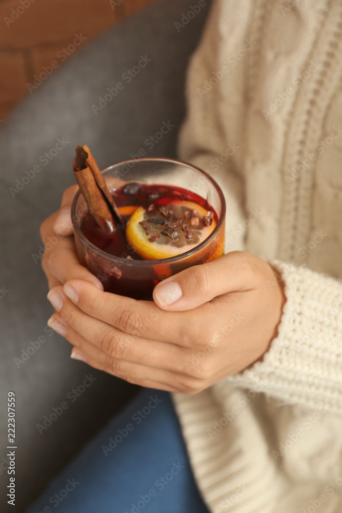 女人拿着一杯美味的热葡萄酒，特写镜头