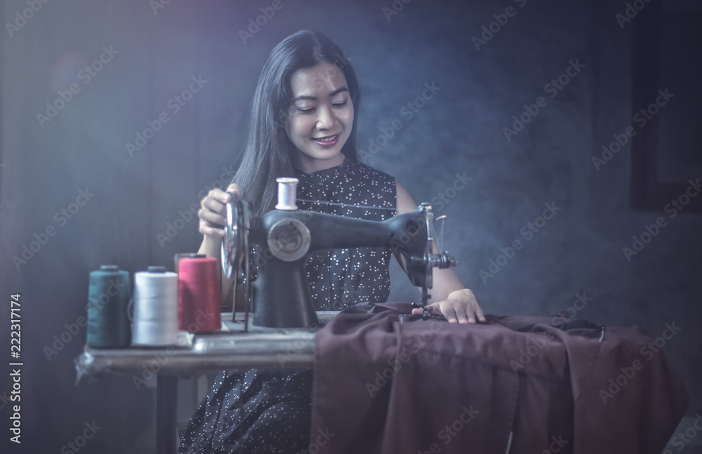 女人在用老式缝纫机。可爱的老年妇女在缝纫衣服