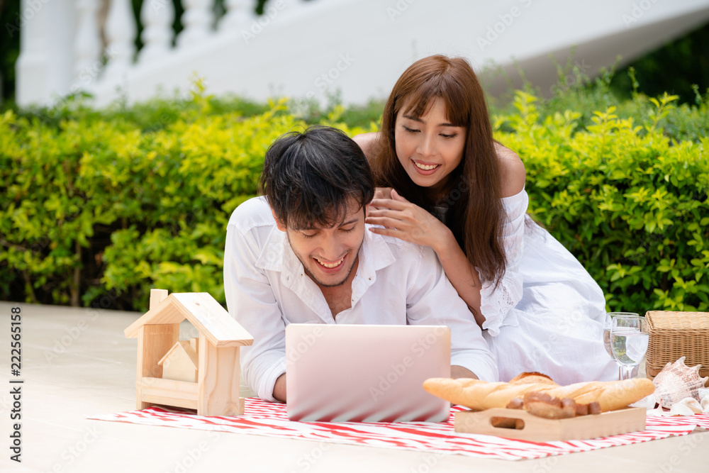 年轻夫妇夏天去公园野餐。