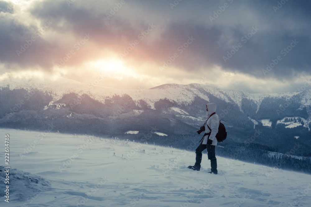 冬季暴风雪中独自一人背着背包在山顶拍摄。旅行理念。鲤鱼