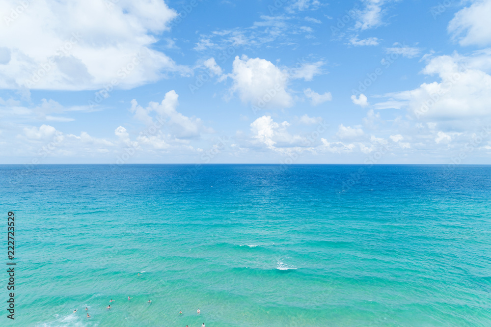 人们喜欢在泰国普吉岛卡伦海滩的热带海水中游泳，海浪拍打沙滩