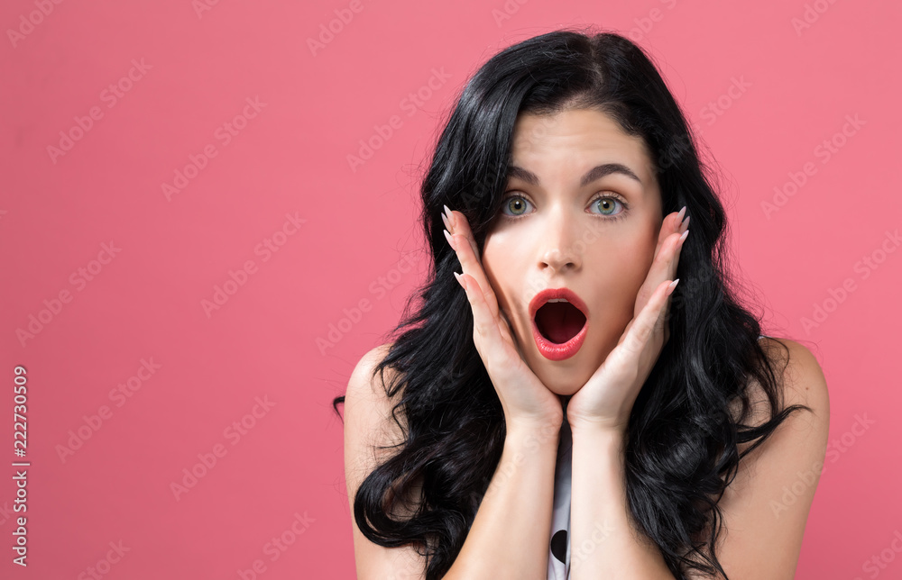 Surprised young woman posing on a solid background