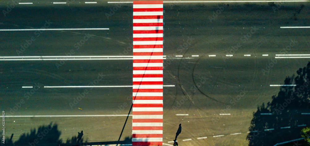 road with a pedestrian crossing of white and red color from the height. Close-up