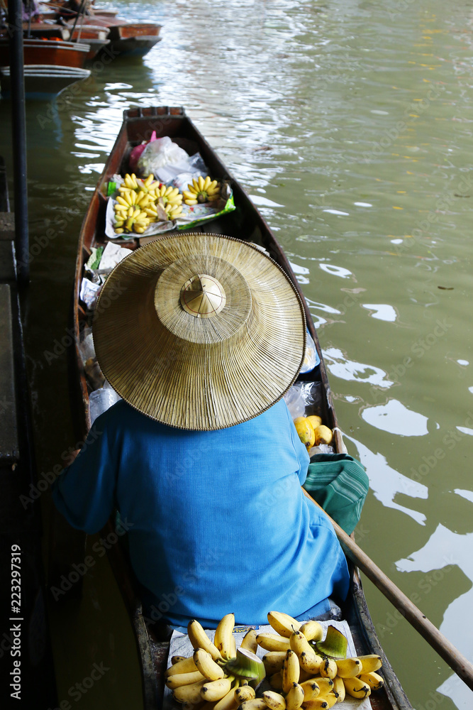 泰国Damnoen Saduak浮动市场，一名妇女在船上交易水果和食物