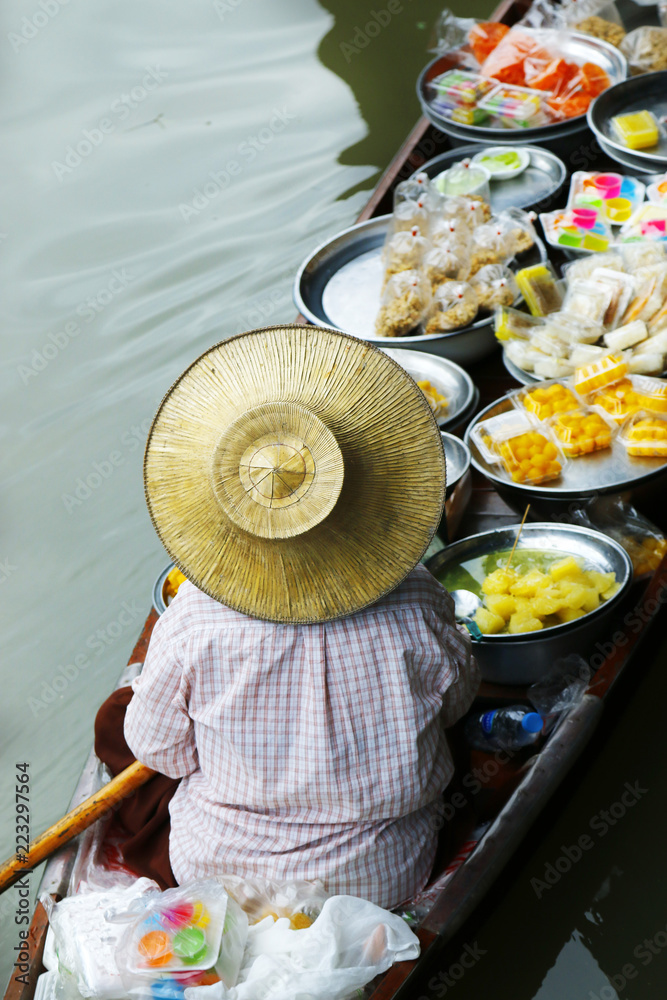 泰国Damnoen Saduak浮动市场，一名妇女在船上交易水果和食物