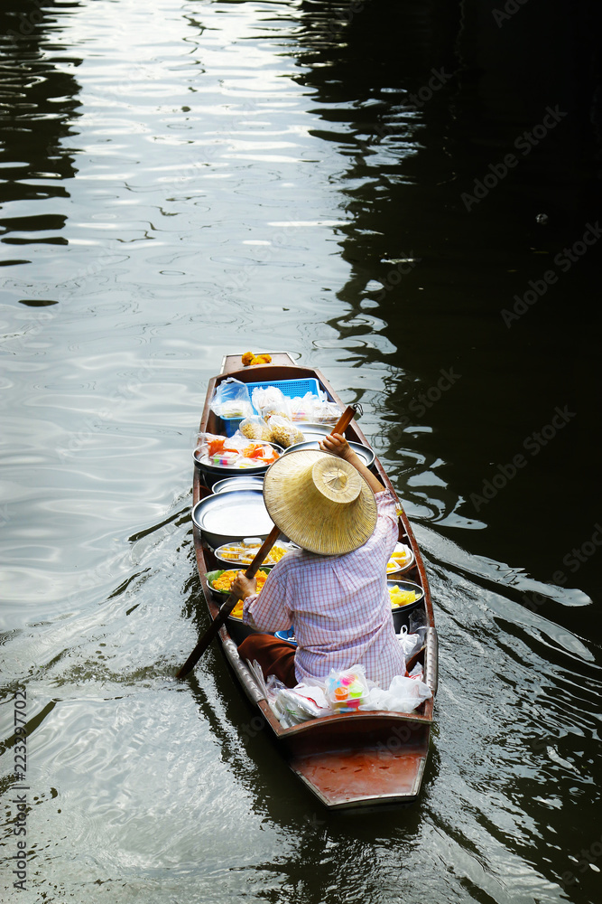 泰国达姆诺恩沙杜瓦克浮动市场，妇女在船上交易水果和食物