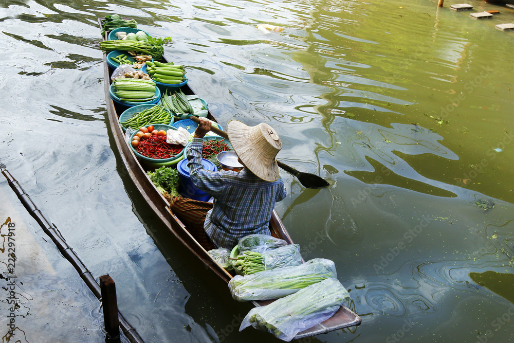 泰国Damnoen Saduak浮动市场，一名妇女在船上交易水果和食物