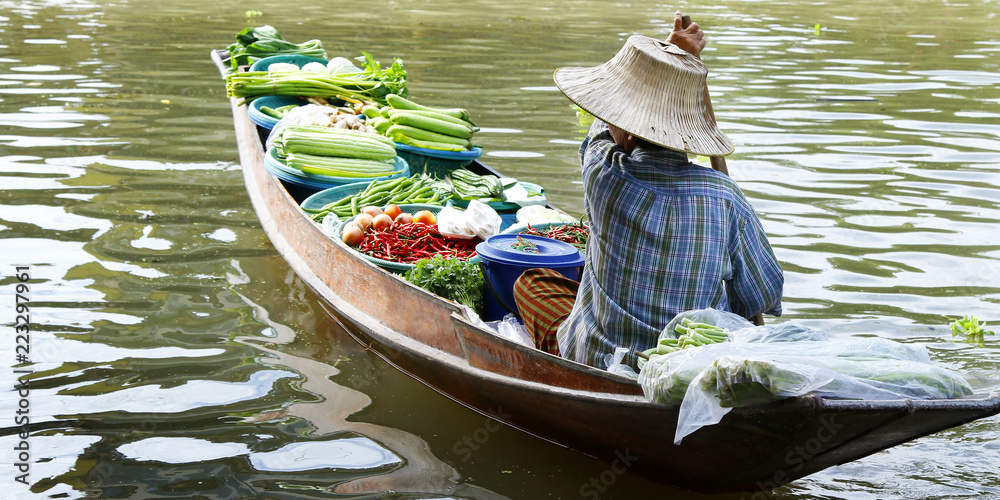 泰国Damnoen Saduak浮动市场，一名妇女在船上交易水果和食物