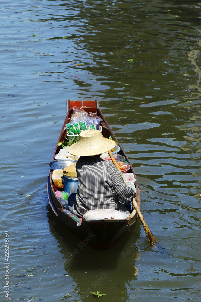 泰国Damnoen Saduak浮动市场，一名妇女在船上交易水果和食物