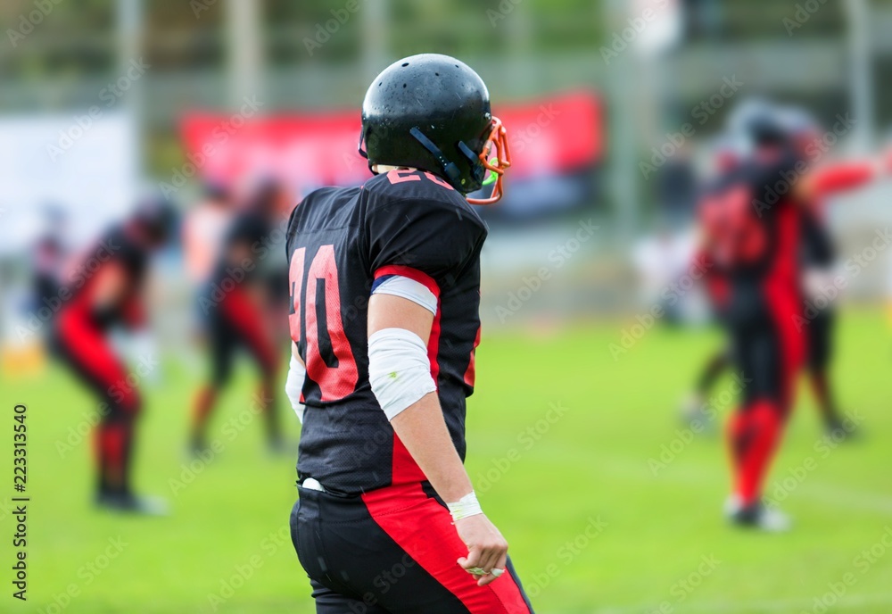 American Football Player With His Teammatess In Background Close