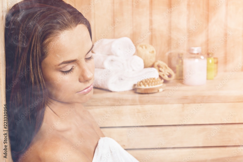 Young beautiful relaxed woman in sauna