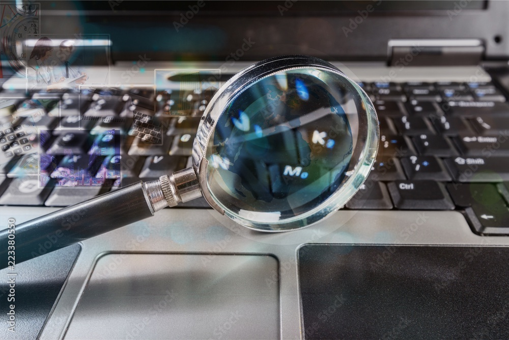 Magnifying glass on notebook, digital background