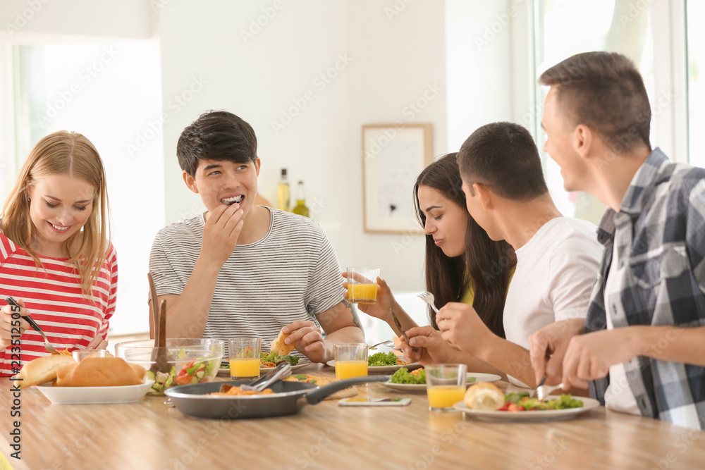 Friends eating at table in kitchen